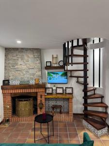 a living room with a fireplace and a spiral staircase at Teresa's sweet home in Cudillero