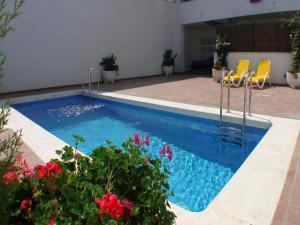 Una piscina en un patio con sillas y flores. en Estartit Park 1-1, en Torroella de Montgrí