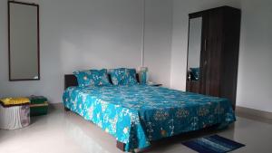 a bedroom with a bed with a blue comforter at Peace Abode Vista 1BHK in Dibrugarh +14 photos