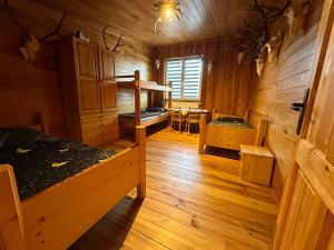 a room with two beds in a wooden cabin at Ubytovanie u Horára in Mokrá Lúka