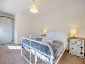 a bedroom with a white bed and a night stand at The Old Jolly in Wainfleet All Saints