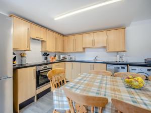 a kitchen with wooden cabinets and a table and chairs at The Old Jolly in Wainfleet All Saints