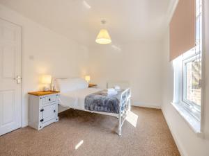 a white bedroom with a bed and a window at The Old Jolly in Wainfleet All Saints