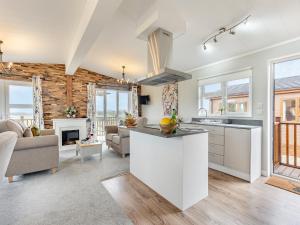 cocina y sala de estar con armarios blancos y chimenea en Church View - Uk46896, en Kinlet