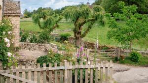 une clôture en bois en face d'un jardin dans l'établissement Pickett Cottage, à Hampnett
