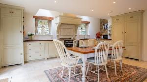 une cuisine avec une table et des chaises en bois dans l'établissement Pickett Cottage, à Hampnett