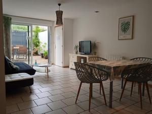 a living room with a table and chairs at T2 proche centre et plage perros guirec in Perros-Guirec