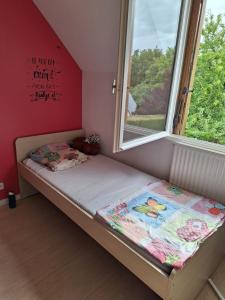 Una cama pequeña en una habitación con ventana. en Les Foyers, en Bretteville-sur-Odon