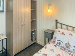 ein kleines Schlafzimmer mit einem Bett und einem Bücherregal in der Unterkunft Pebbles - Uk48098 in Haverfordwest