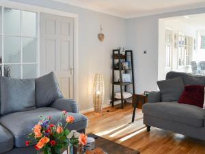 a living room with two couches and a table at April Cottage in Sewerby