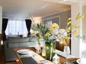 a living room with a vase of flowers on a table at April Cottage in Sewerby