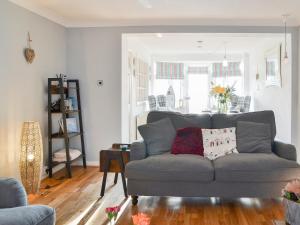 a living room with a gray couch and a table at April Cottage in Sewerby