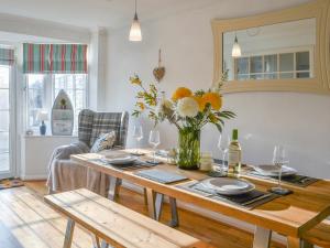 a living room with a table with a vase of flowers at April Cottage in Sewerby +24 photos