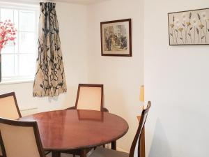ein Esszimmer mit einem Holztisch und Stühlen in der Unterkunft Windmill Cottage in Little Eaton