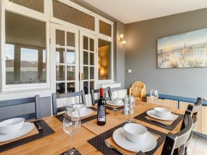 a dining room with a table with a bottle of wine at Court House in Porthcawl