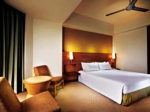 Habitación de hotel con 1 cama y 2 sillas en Resorts World Genting - Resort Hotel, en Genting Highlands