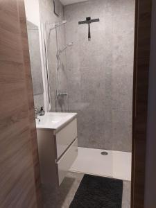 a bathroom with a sink and a shower with a glass door at Modern and cozy apartment in Middelkerke