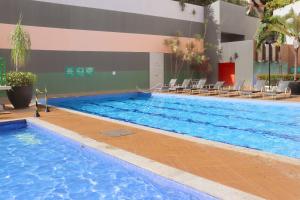 a large swimming pool with chairs in a building at Veredas do Rio Quente Family in Rio Quente