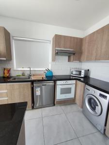 a kitchen with a washer and a sink and a dishwasher at Luxury Villa Milo with Private Pool - Cavo Greco in Protaras