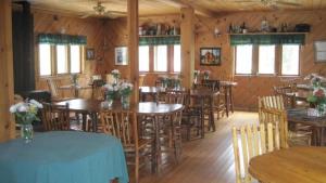 a restaurant with wooden tables and chairs and windows at Drakesbad Guest Ranch in Chester