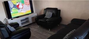 Una sala de estar con dos sillas y un televisor de pantalla plana. en Dordouce, en Marsella