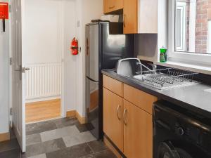 a kitchen with a sink and a refrigerator at Turtle's Nest in Newbiggin-by-the-Sea
