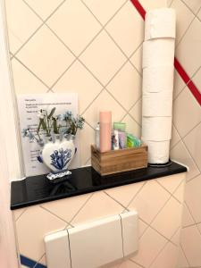 a shelf with toilet paper and a vase at Irene's Palace - The Hague Scheveningen in The Hague
