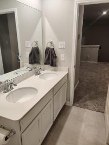a bathroom with two sinks and a large mirror at Comfortable family house in Hot Wells