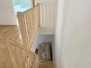 a room with a stairway with a couch underneath it at Duplex cosy - à 100 m de la gare - lumineux & confortable in Châtellerault +9 photos