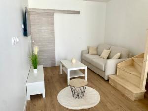 a living room with a couch and a table at Duplex cosy - à 100 m de la gare - lumineux & confortable in Châtellerault
