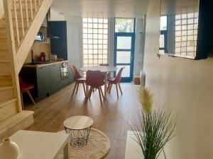 a kitchen and dining room with a table and chairs at Duplex cosy - à 100 m de la gare - lumineux & confortable in Châtellerault