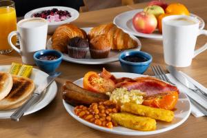 a table with plates of breakfast food on it at Holiday Inn Express Edinburgh - Leith Waterfront by IHG in Edinburgh