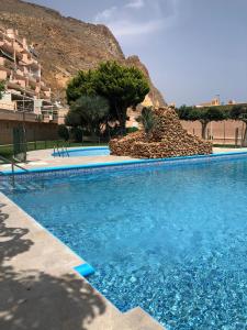 a large blue swimming pool in front of a mountain at Apartamento Exclusivo Frente al Mar in Aguadulce