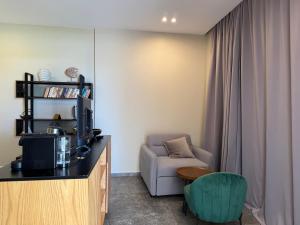 a living room with a tv and a chair at Luna Mare Boutique Seaside in Borsh