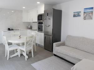 a kitchen and living room with a table and a couch at Casa de Praia Daniel 2 in Lavra