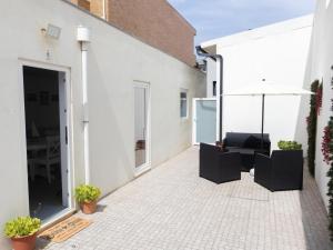 an outdoor patio with two chairs and an umbrella at Casa de Praia Daniel 2 in Lavra