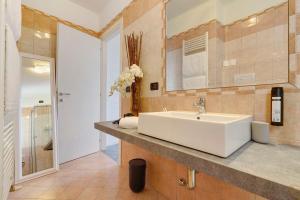 une salle de bains avec un lavabo blanc et un miroir dans l'établissement Appartamento Il Campanile, à Tignale 19 autres photos