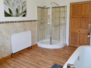 un baño con ducha y bañera en Magnolia Lodge, en Sheringham 3 fotos más