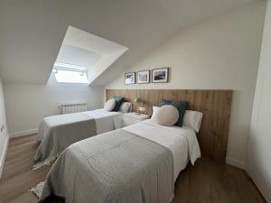 two beds in a room with white walls at Doña Carmen en el corazón Cangas Onís VUT-6783-AS in Cangas de Onís