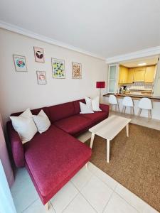 a living room with a red couch and a table at Summer breeze in Puerto de Santiago +21 photos