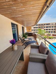 a balcony with couches and chairs on a building at Summer breeze in Puerto de Santiago