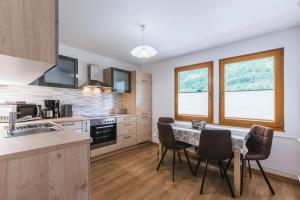 a kitchen with a table and chairs in it at Karavanke Holiday Getaway in Hrušica