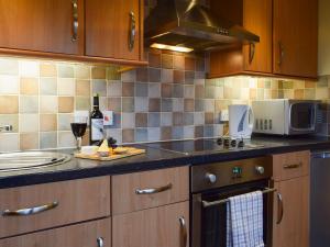 a kitchen with a counter with a sink and a microwave at Inn Cottage in Glendevon