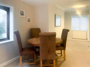 Sunbury Cottage في Clanfield: غرفة طعام مع طاولة وكراسي خشبية