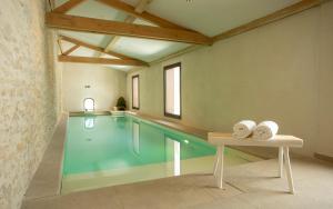 a swimming pool with two towels on a table next to it at Domaine Les Lanternes in Saint-Cyr-au-Mont-dʼOr