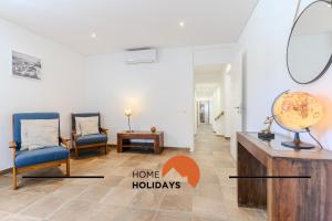a living room with two chairs and a table with a globe on it at #331 Casa Chico Rita by Home Holidays in Sesmarias