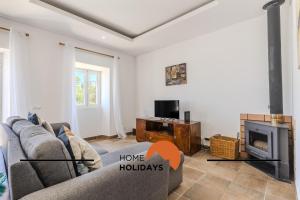 a living room with a couch and a fireplace at #331 Casa Chico Rita by Home Holidays in Sesmarias