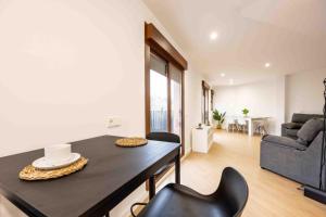 ein Wohnzimmer mit einem schwarzen Tisch und Stühlen in der Unterkunft Ático Suite 3 habitaciones con terraza in Cartagena