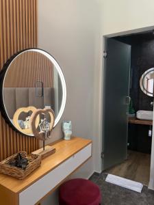 a bathroom with a round mirror on a wooden counter at Luna Mare Boutique Seaside in Borsh