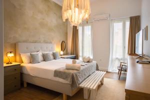 a bedroom with a large bed and a chandelier at Dimora - A Spacious Luxury Penthouse in Town's Heart in Corfu Town